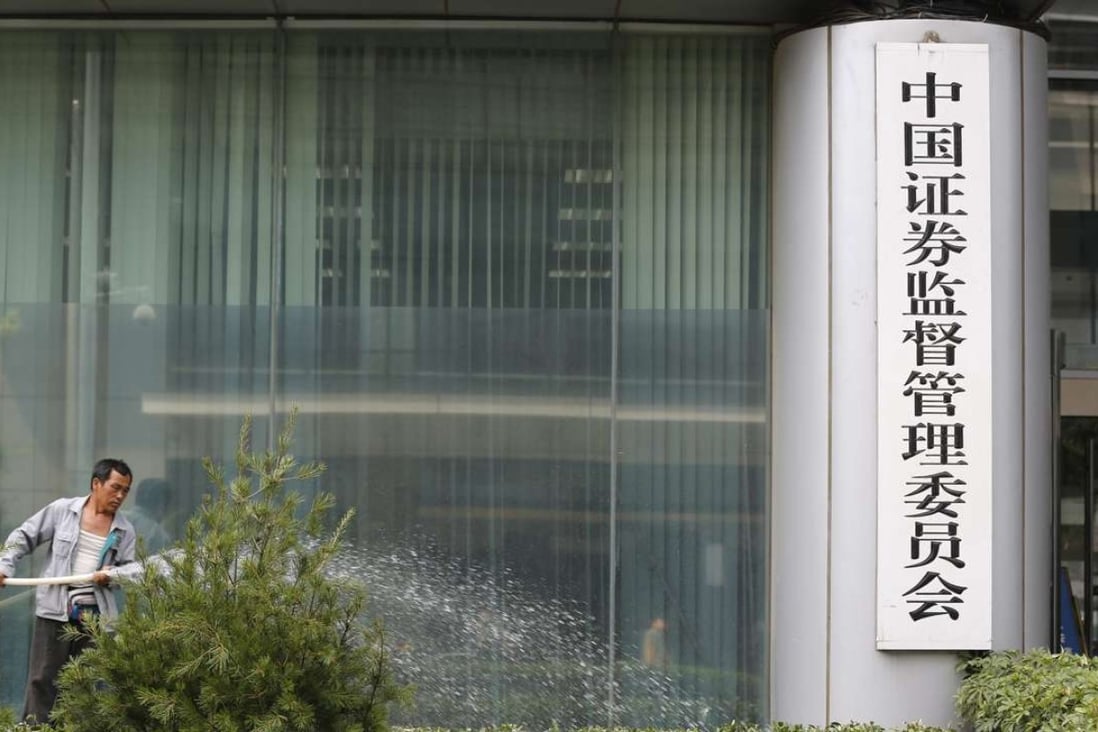 A gardener waters plants outside the China Securities Regulatory Commission headquarters in Beijing. Photo: EPA