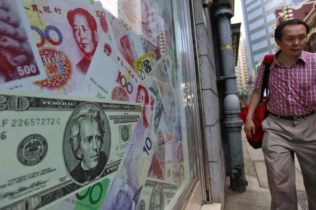 A man walks past a display of oversized banknotes outside a foreign exchange office in Hong Kong. Photo: EPA