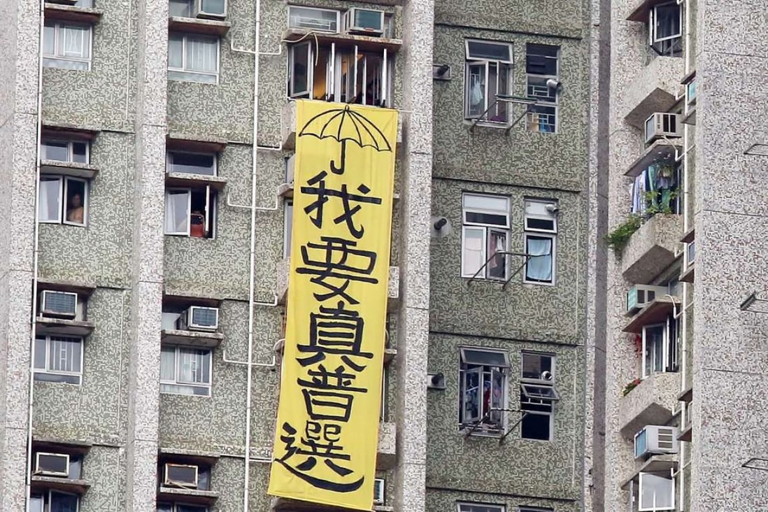 A large yellow banner draped outside a residential building next to an elderly home in Tseung Kwan O visited by Zhang Dejiang on Thursday. Photo: Nora Tam