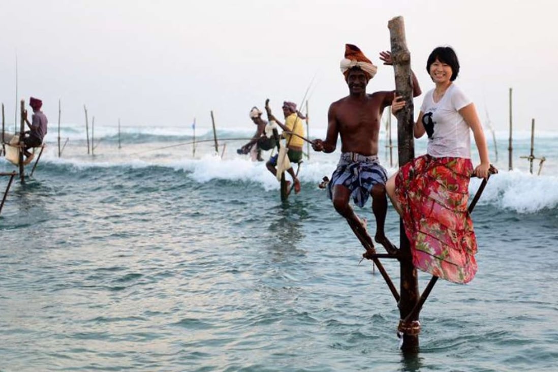 A Chinese tourist poses for a photo with a fisherman in Sri Lanka. Photo: Xinhua
