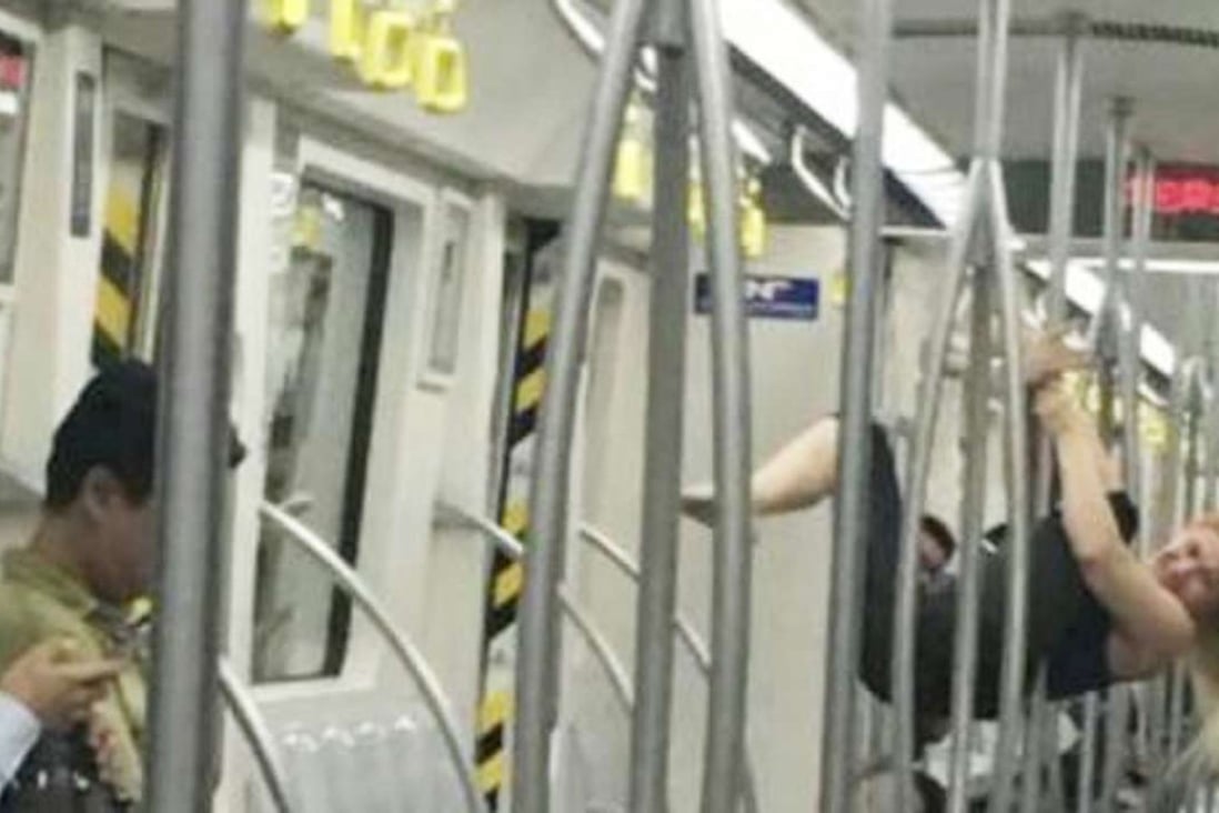 A foreign woman performs pole dance in a subway train in Tianjin on Thursday night. Photo: SCMP Pictures