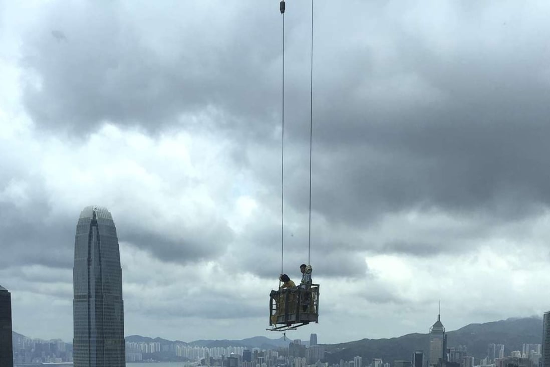 *Hong Kong construction workers against the city’s skyline.