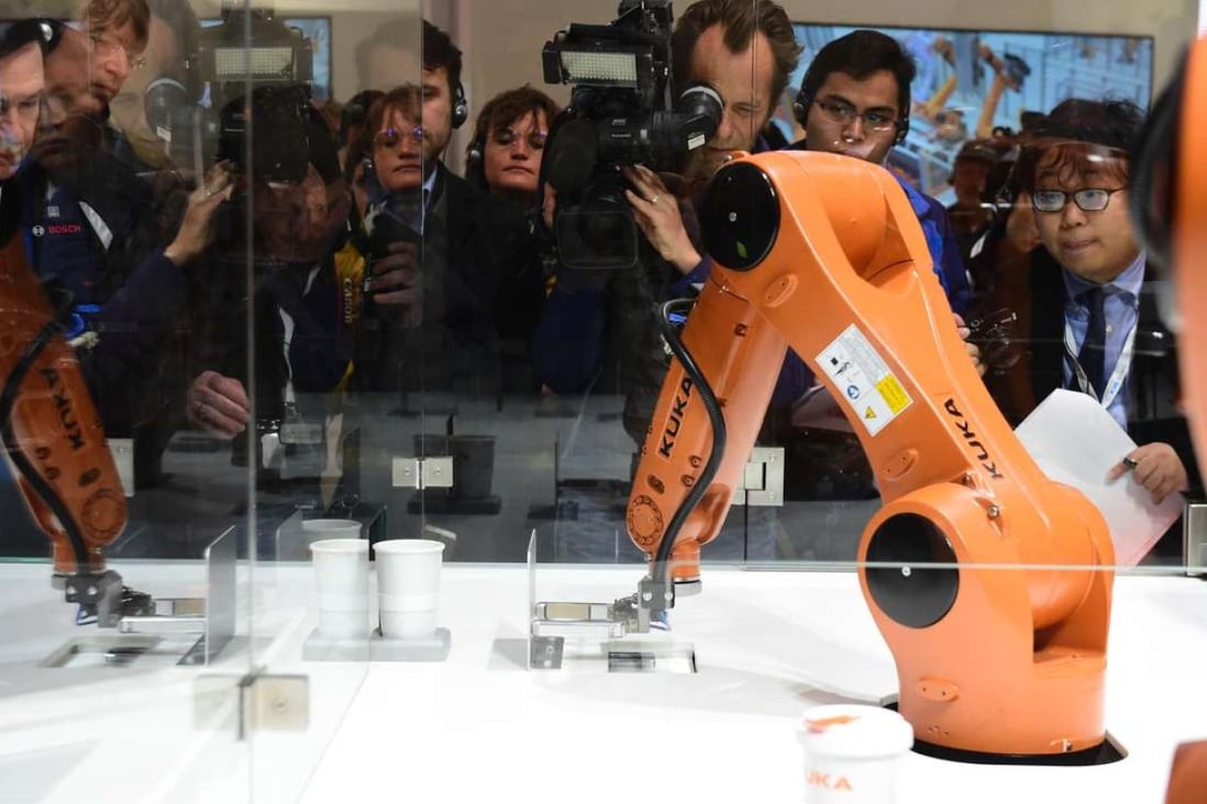 A robot prepares a cup of coffee at the booth of robotics manufacturer Kuka, on the eve of the opening of the Hanover Fair earlier this year. Photo: AFP