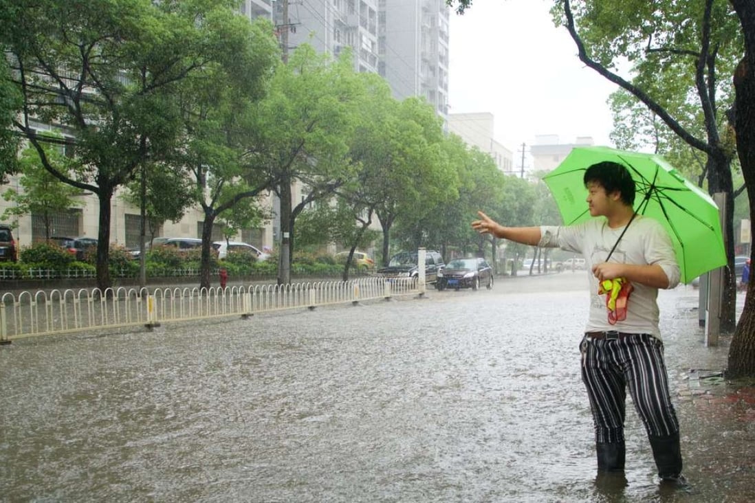 A resident hails a taxi on a waterlogged street in Nanchang, capital of Jiangxi province. Home prices in the city have been relatively flat compared with other cities. Photo: Xinhua