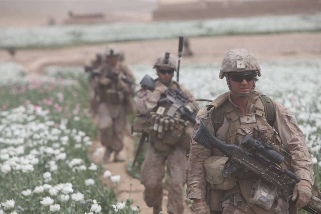 US soldiers patrolling a poppy field in Afghanistan. Intoxication and war have been intimately linked since the dawn of history.