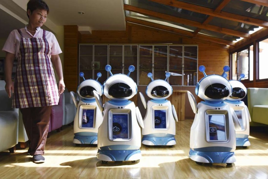 A caregiver walks past robots at a nursing home in Hangzhou in eastern China's Zhejiang province. Photo: AP