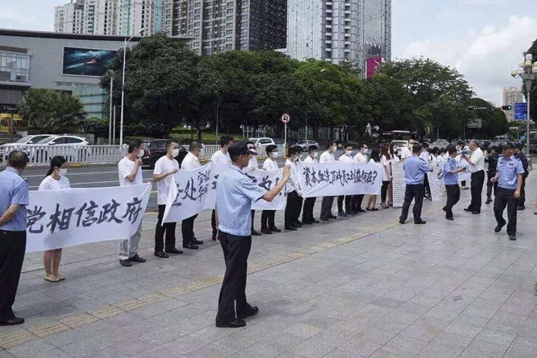 Vanke employees, in masks and holding banners protest in Shenzhen yesterday. Photo: SCMP Pictures