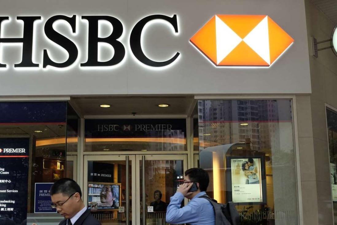 Two men walk past an HSBC branch office in Hong Kong. The average customer here has over 4.5 separate banking relationships, one of the highest rates in the world. Photo: Vincent Yu, AP