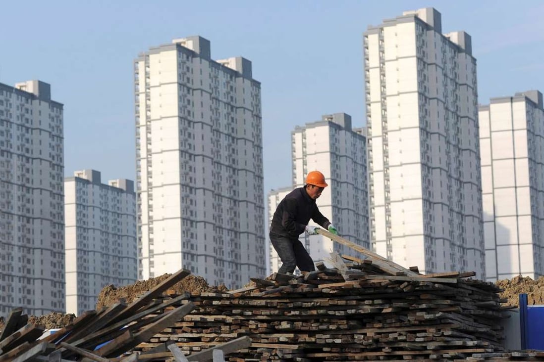 A worker selects wooden planks at a residential construction site in Hefei, Anhui province. Photo: Reuters
