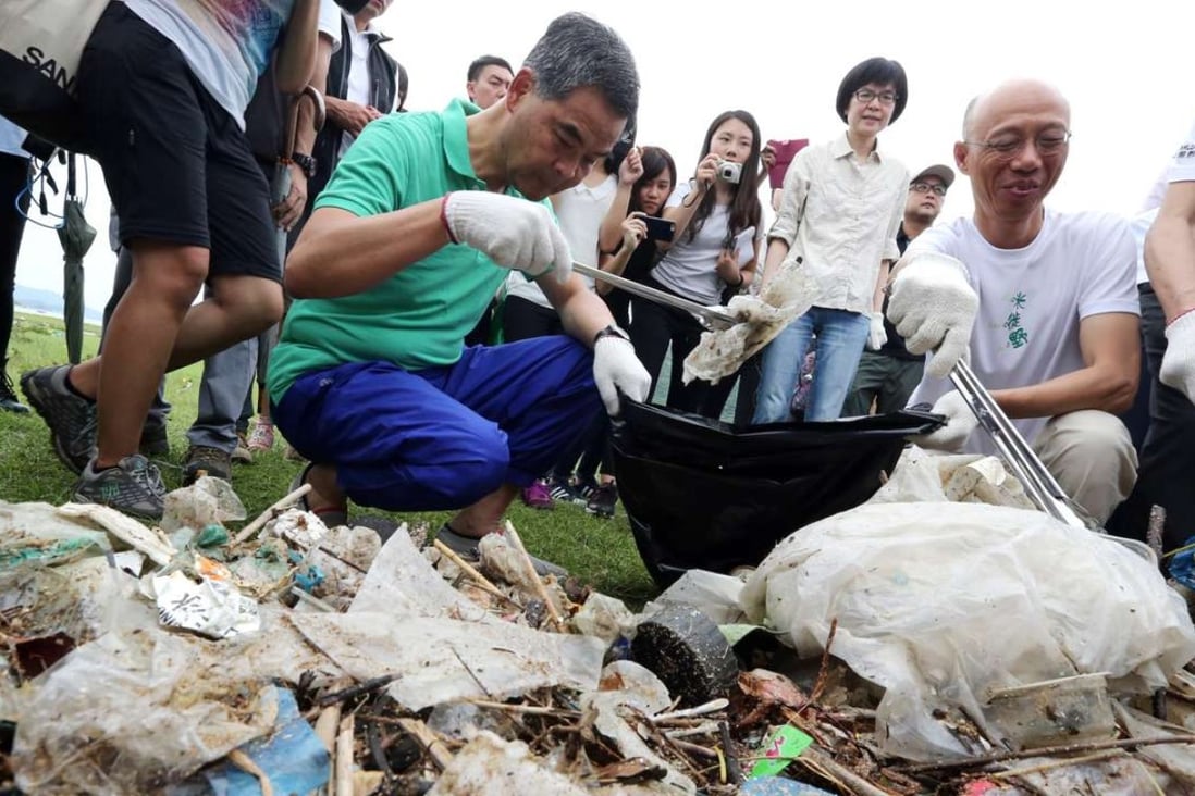 Chief Executive Leung Chun-ying and environment minister Wong Kam-sing collect rubbish at Shui Hau on Lantau. Photo: Felix Wong