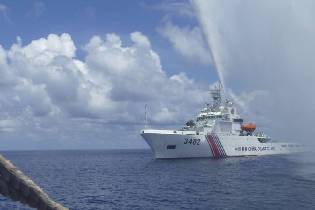 A Chinese coastguard vessel trains its hoses on Filipino fishermen off Scarborough Shoal in the South China Sea in September last year. Photo: AP