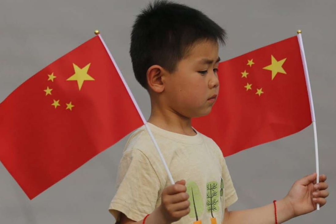 A boy holding the Chinese national flag. Photo: EPA