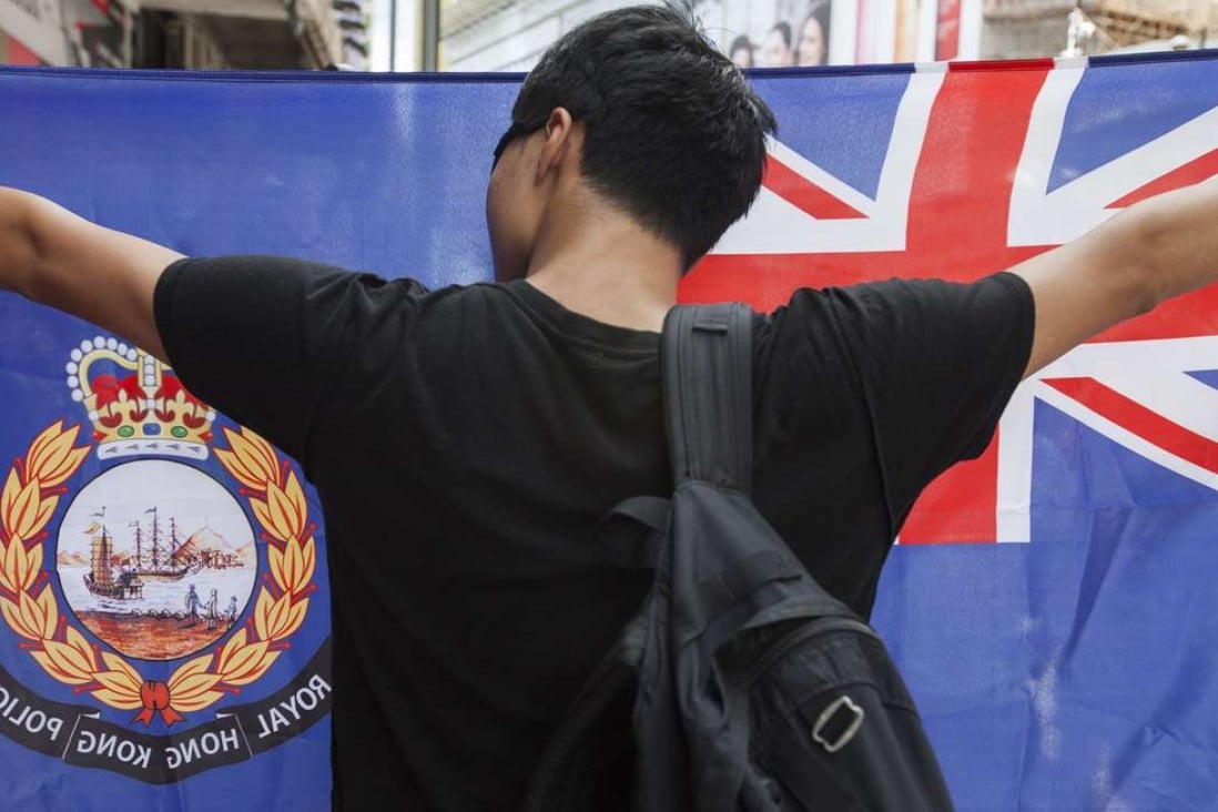 A pro-independence protester holds up a flag that recalls British colonial days during the annual July 1 rally in the city. Photo: EPA