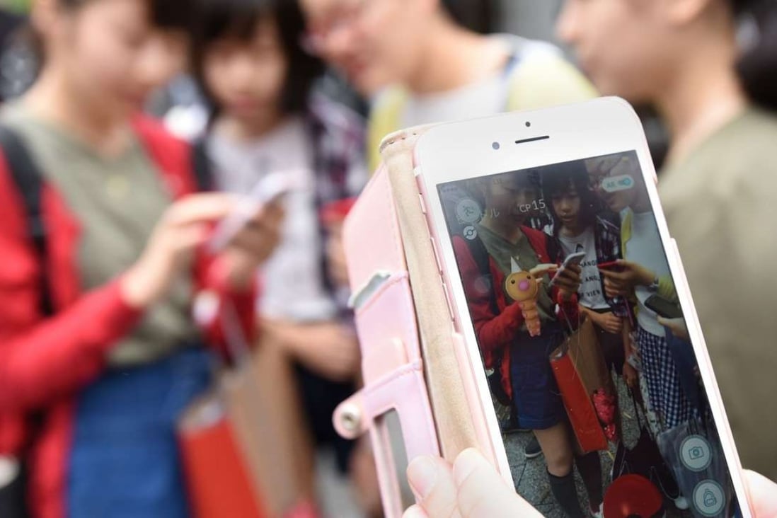 Schoolgirls play Pokemon Go on their mobile phones in Tokyo. Photo: AFP