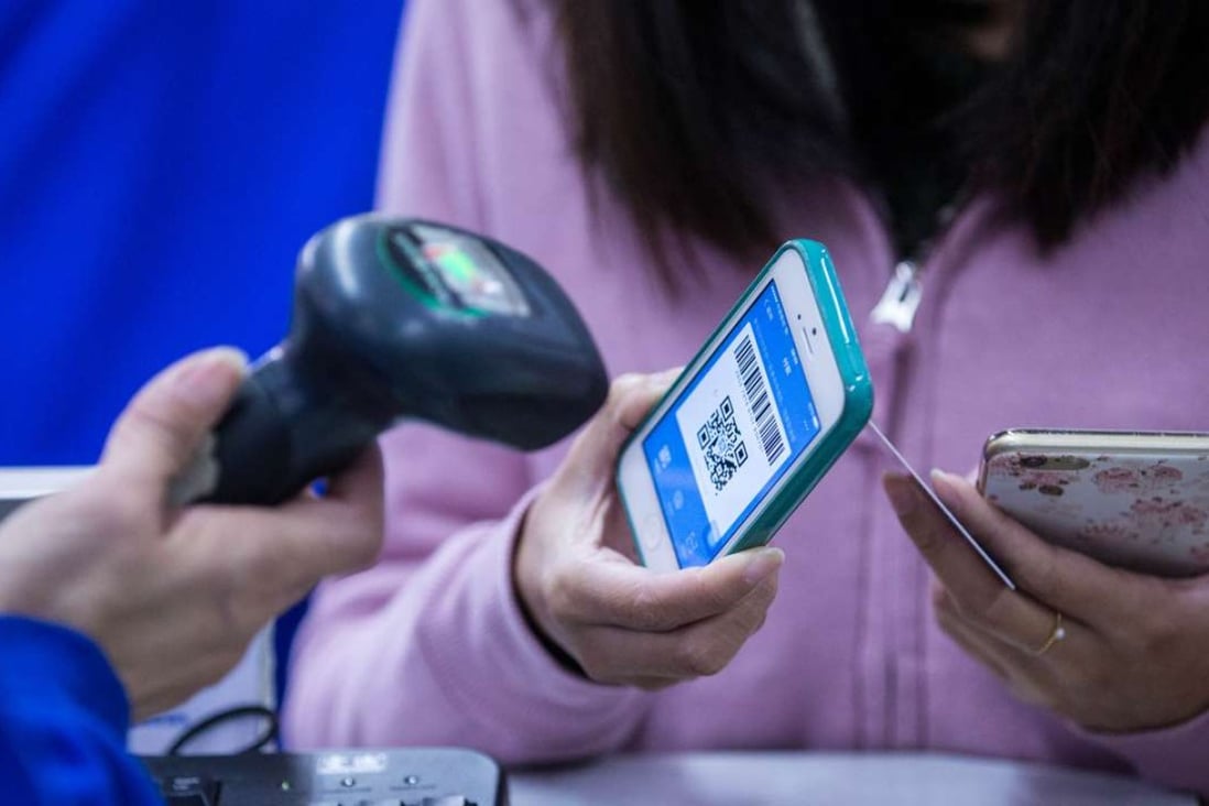 A customer with a barcode on her Apple iPhone scanned by a cashier for payment through Alipay. Photo: Martin Chan