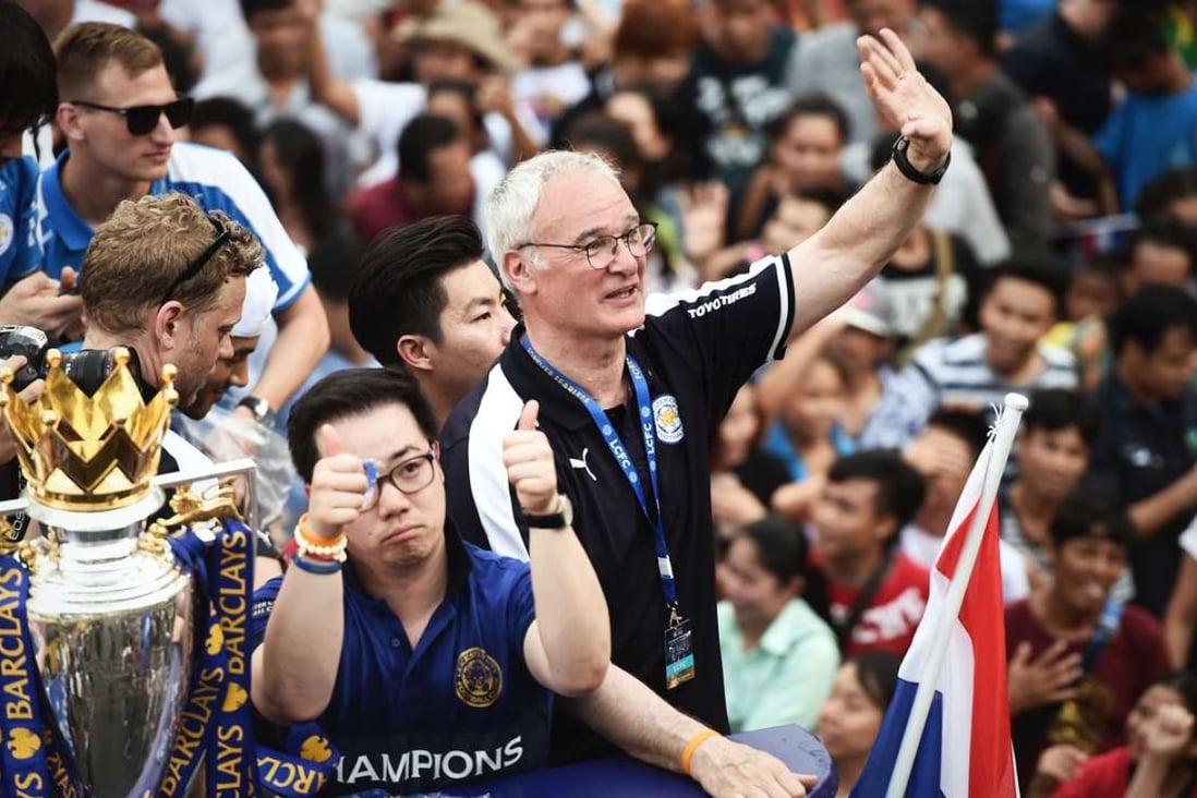 Leicester City football manager Claudio Ranieri waves to Thai supporters during an open-bus parade in Bangkok to celebrate his side winning the English Premier League. The club is owned by Thai billionaire Vichai Srivaddhanaprabha. Photo: AFP