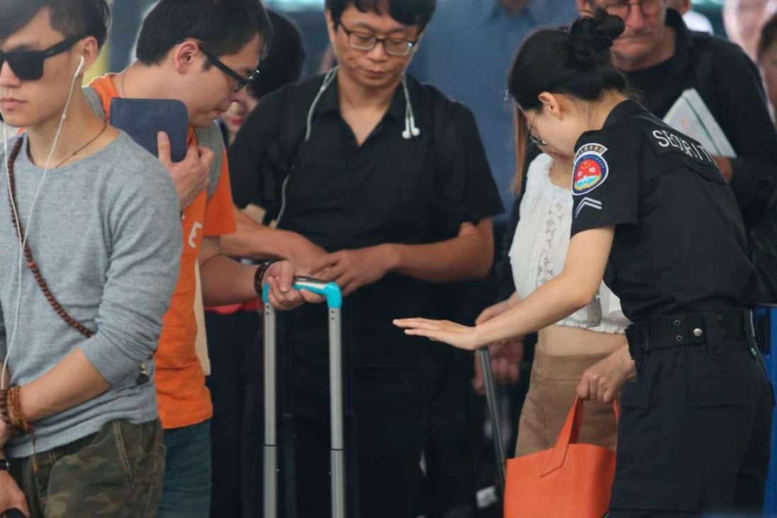 A security personnel conducts checks on travellers at Shanghai’s Pudong airport. Photo: SCMP Pictures