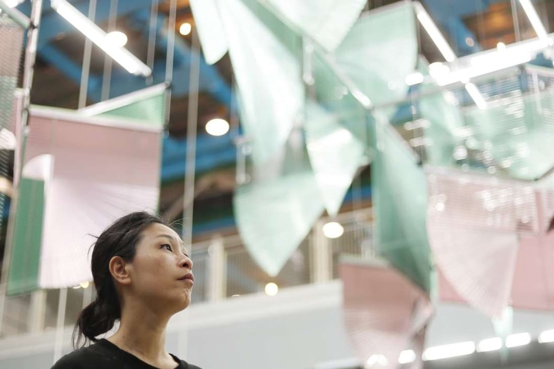 South Korean artist Haegue Yang poses under her installation Lingering Nous at the Centre Pompidou. The monumental artwork is an assembly of colourful Venetian blinds. Photo: AFP
