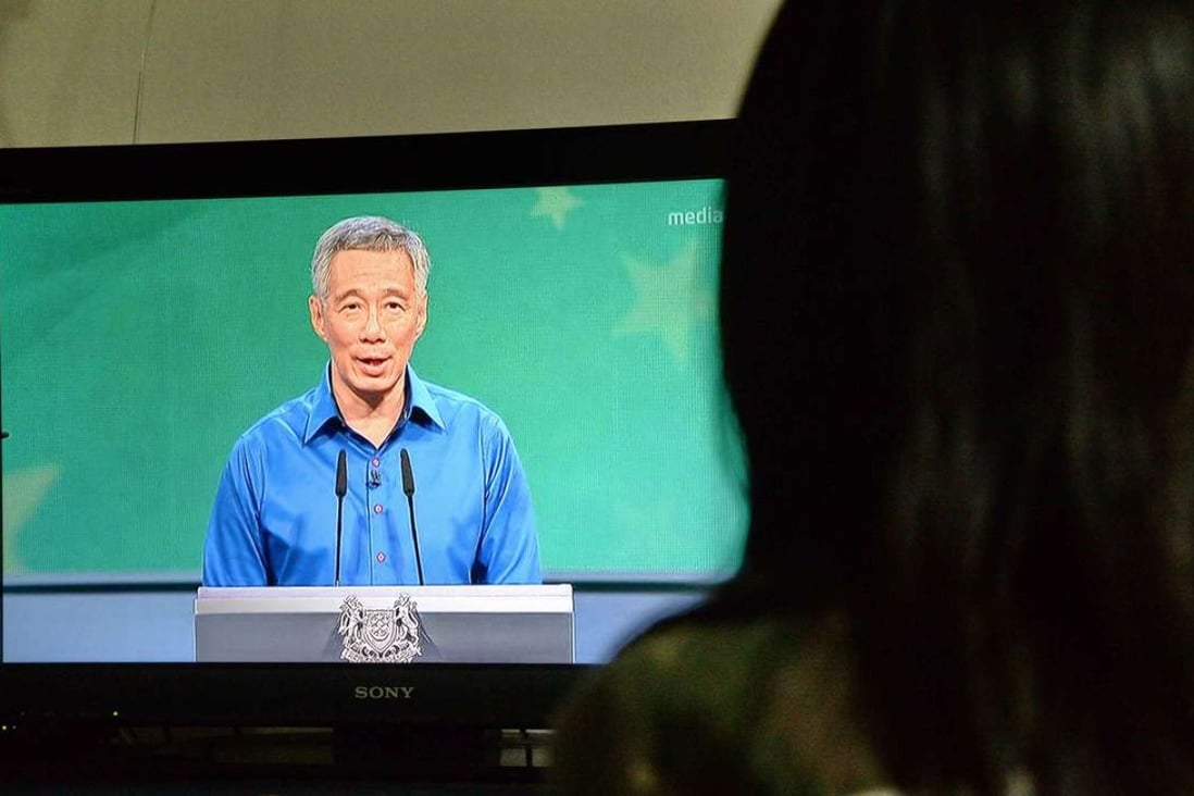A Singaporean resident watches a live televised speech by Prime Minister Lee Hsien Loong after he became ill during a National Day Rally on August 21, 2016. Photo: AFP