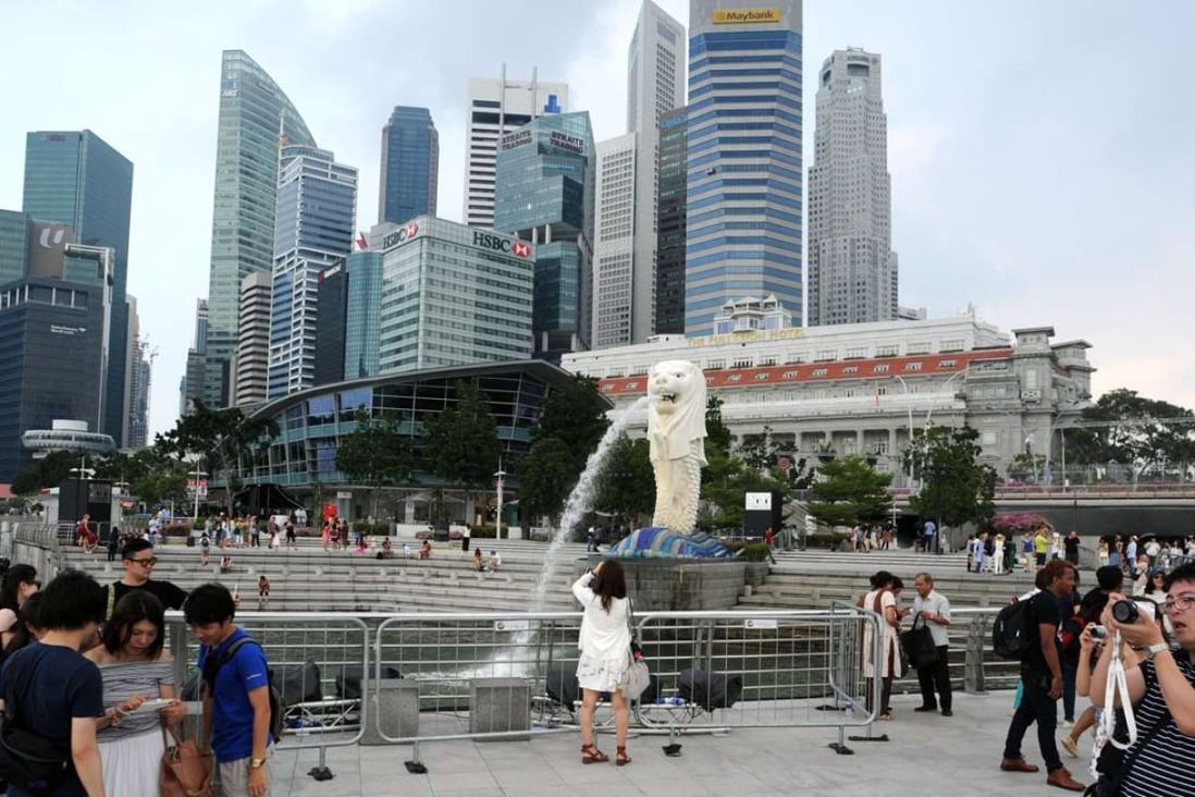 Tourists visit Singapore's Merlion Park as hotels struggle from a glut of rooms. Photo: Xinhua