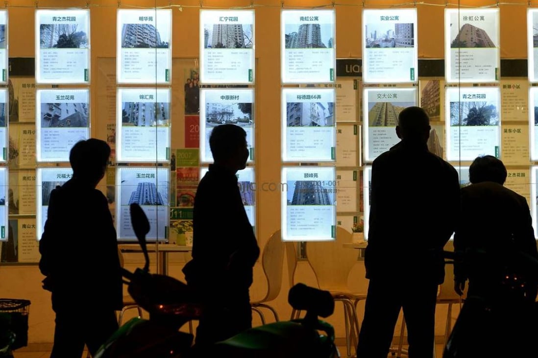 Potential Shanghai home buyers view ads posted on the window of a Lianjia Real Estate Agency branch in March. Photo: Lai Xinlin