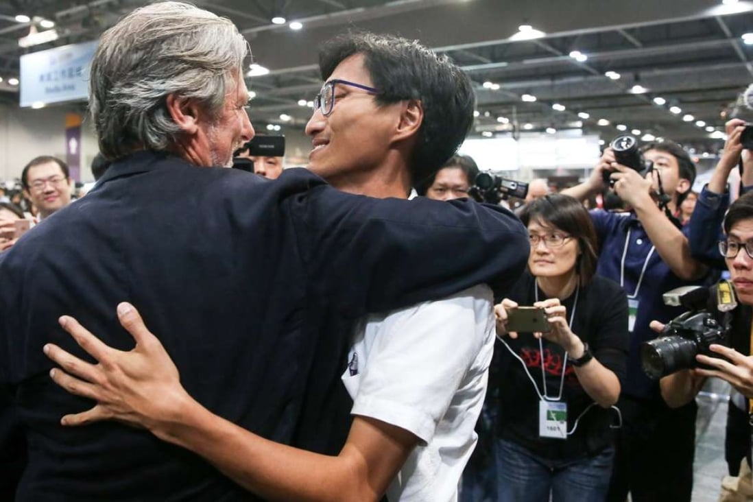 Paul Zimmerman, one of the five pan-democratic candidates who stopped campaigning two days before the election, hugs Eddie Chu Hoi-dick after he won a seat in New Territories West. Photo: Sam Tsang