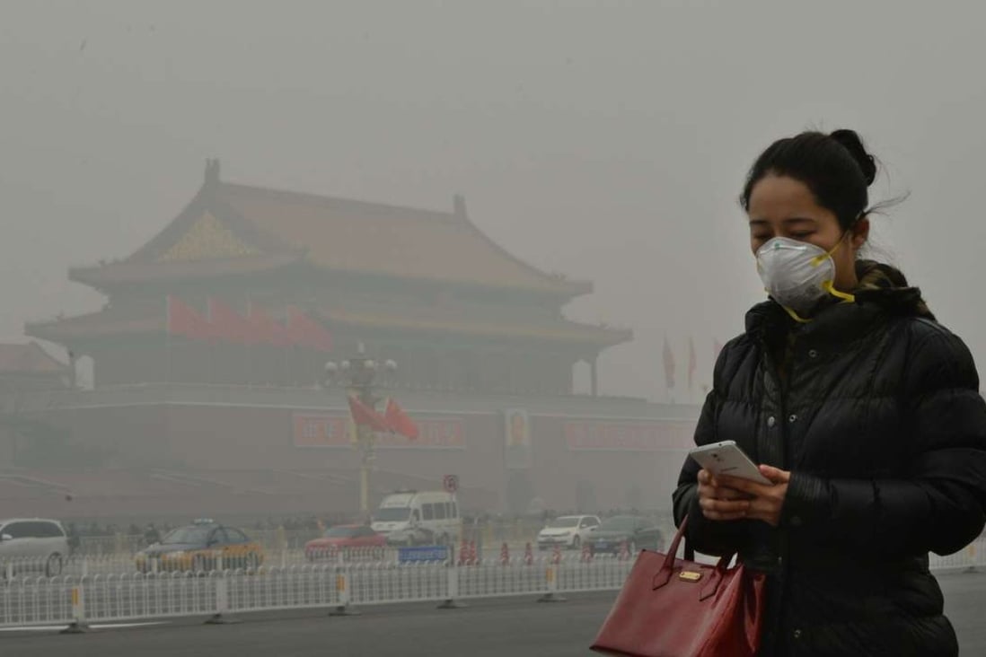 A woman walks beside Tiananmen Square as heavy air pollution shrouds Beijing. Photo: AFP