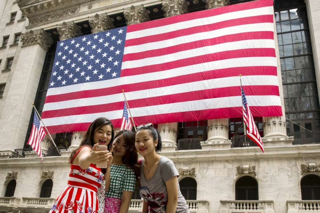 Chinese tourists outside the New York Stock Exchange. Spending on travel has become a priority for many of the country’s younger generation, according to a new HSBC survey. Photo: Reuters