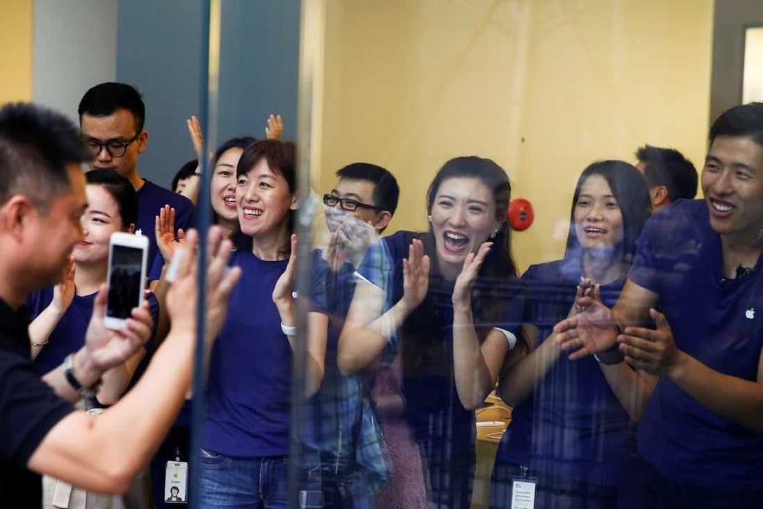 Staff greet a customer as he arrives to purchase an iPhone 7 at an Apple store in Beijing. Photo: Reuters