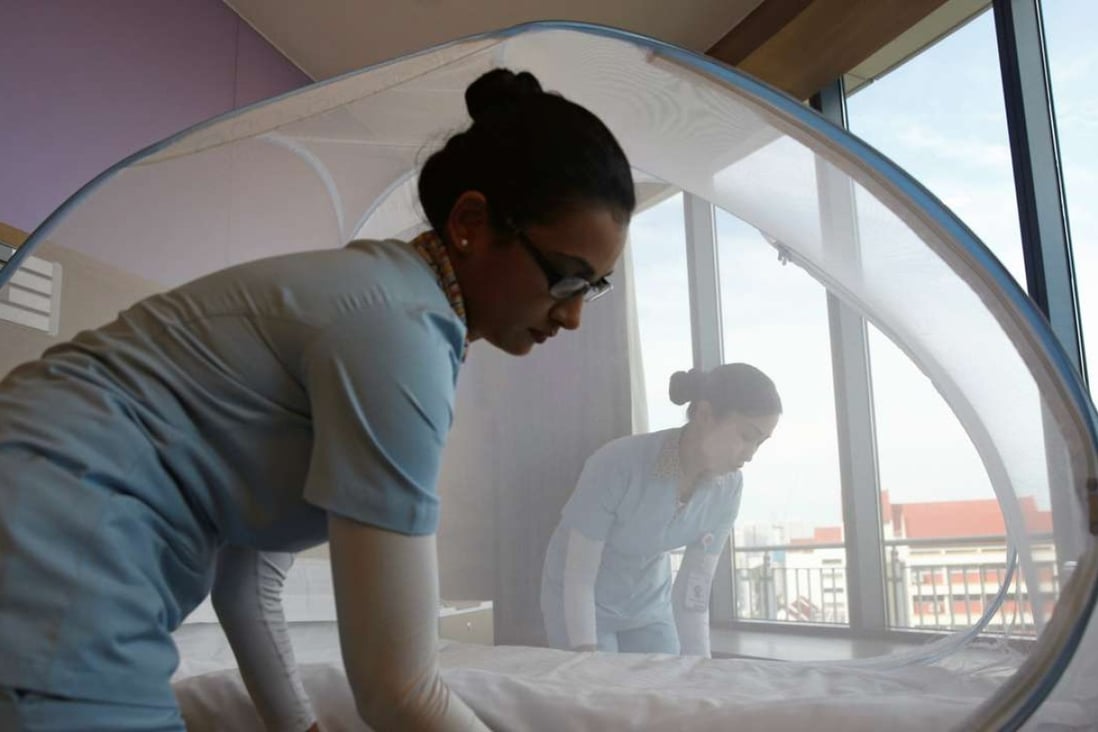 Nurses set up a mosquito tent over a hospital bed, as part of a precautionary protocol for patients who are infected by Zika, at Farrer Park Hospital in Singapore. Photo: Reuters