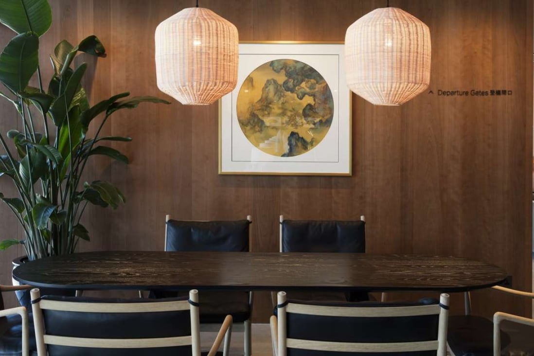 The contemporary lounge area is designed to create a warm and welcoming ambience with cherry wood panelling, a table in black walnut and rattan ceiling lights. Photo: StudioIlse