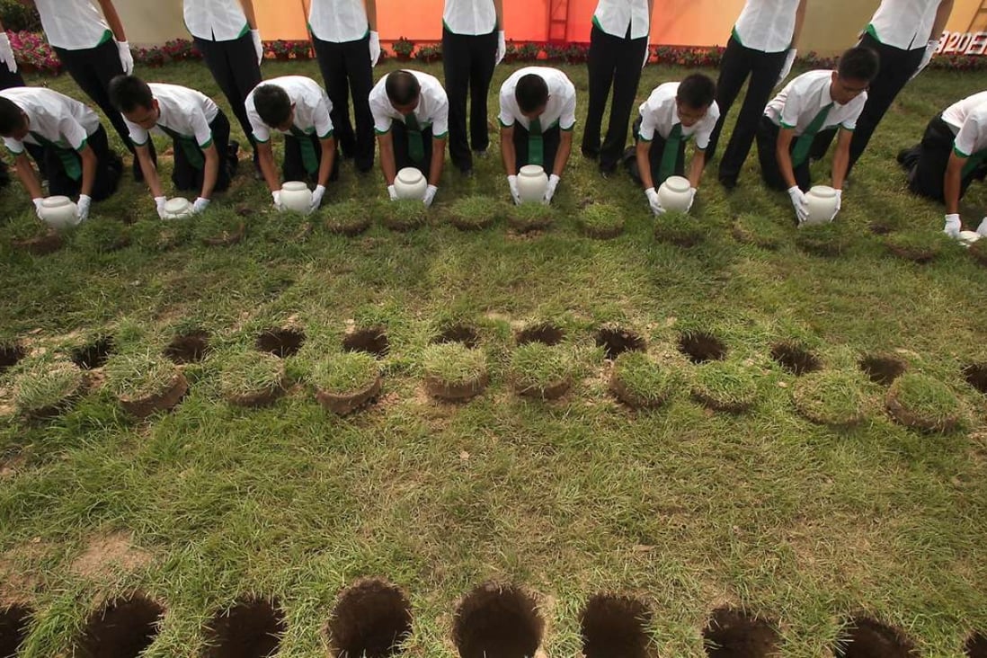Young Chinese soldiers perform burial duties of 280 biodegradable urns during a collective eco-burial ceremony at the cemetery of Tianjin on July 20, 2010. The patented urns in China, are designed to contribute to the protection of the environment as space at cemeteries has become a serious issue in a country which has 1/5 of the world's population and has a death rate of up to 10 million a year. Photo: Imagechina