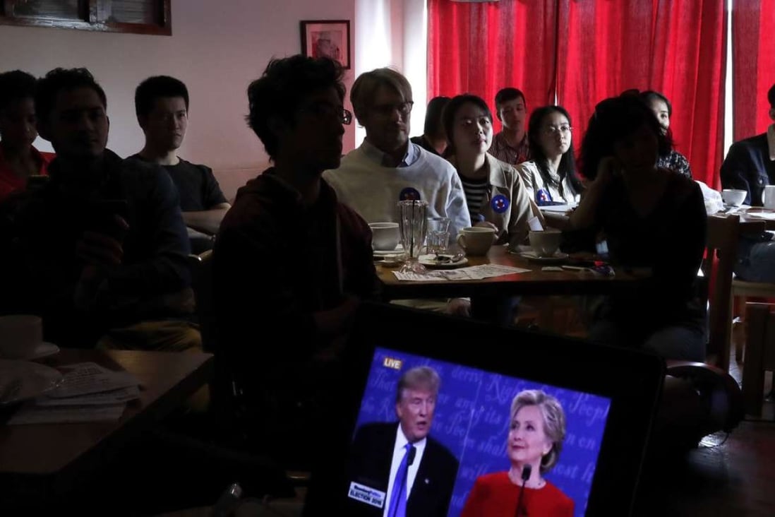 People watch live broadcasting of the U.S. presidential debate between Democratic presidential nominee Hillary Clinton and Republican presidential nominee Donald Trump, at a cafe in Beijing, Tuesday, Sept. 27, 2016. (AP Photo/Andy Wong)