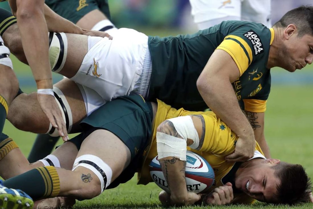 Australia’s Sean McMahon is tackled by South Africa’s Francois Louw. Photo: AP