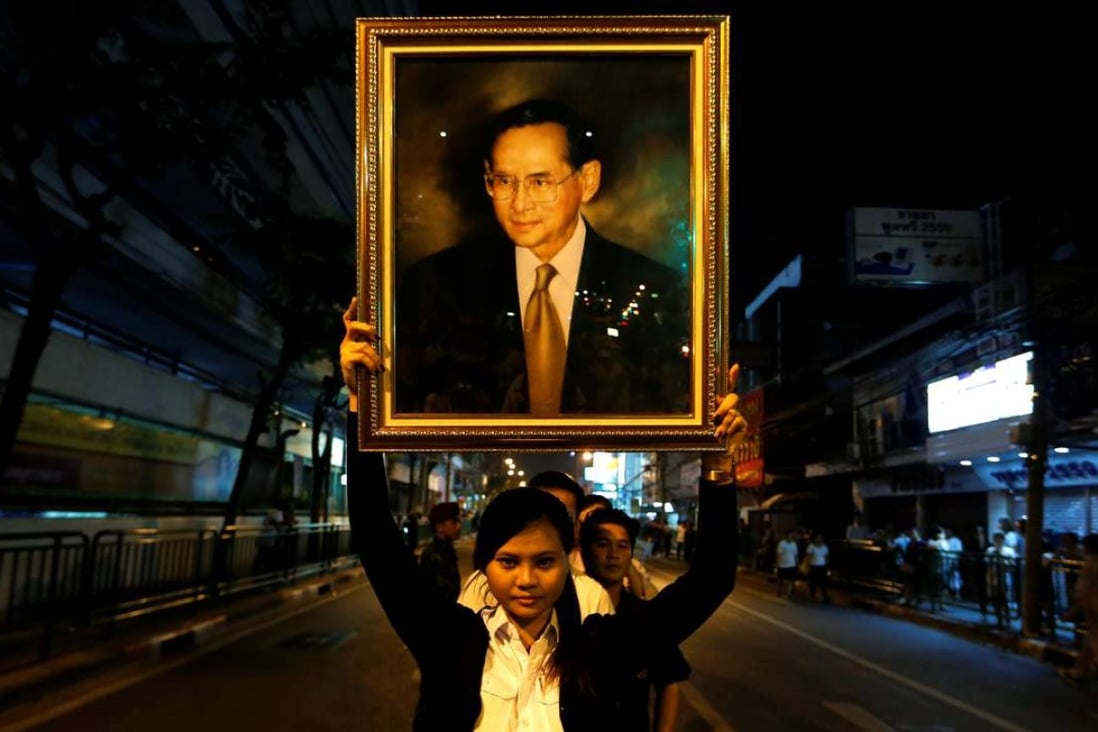 A woman poses with a portrait of Thailand’s late King Bhumibol Adulyadej. Photo: Reuters