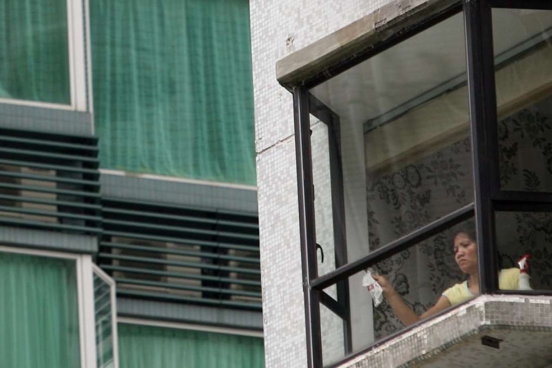 A maid cleaning a window at The Legend, Jardine Lookout. Photo: SCMP Pictures