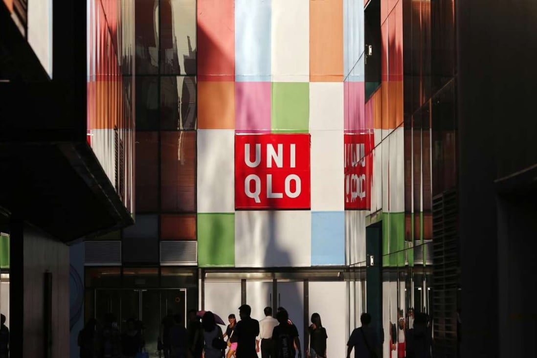 People stand outside a Uniqlo shop in Beijing in this August 24, 2013 file photo. Fast retailing, operator of the Uniqlo clothing chain, said on January 27, 2014 it plans to list its shares on the Hong Kong exchange on March 5 as it aims to boost its presence in the region and expand its investor base globally. Picture taken August 24, 2013. REUTERS/Petar Kujundzic/Files (CHINA - Tags: BUSINESS)