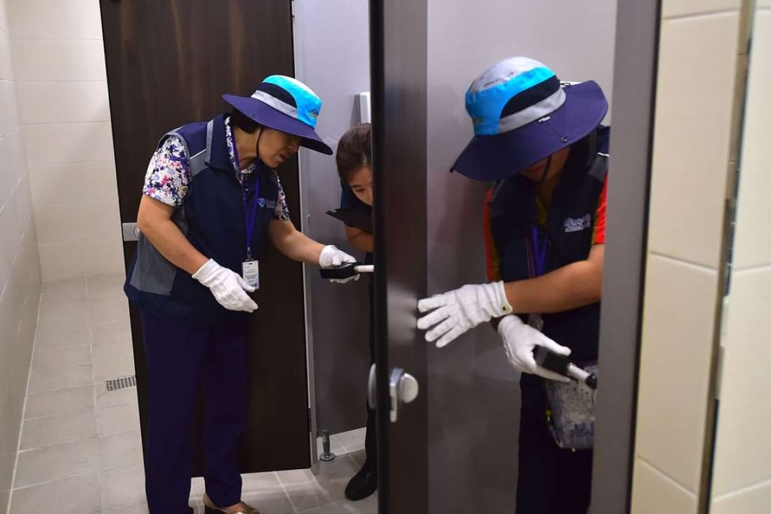 Members of Seoul hidden camera-hunting squad inspect a women's bathroom stall at a museum. Photo: AFP