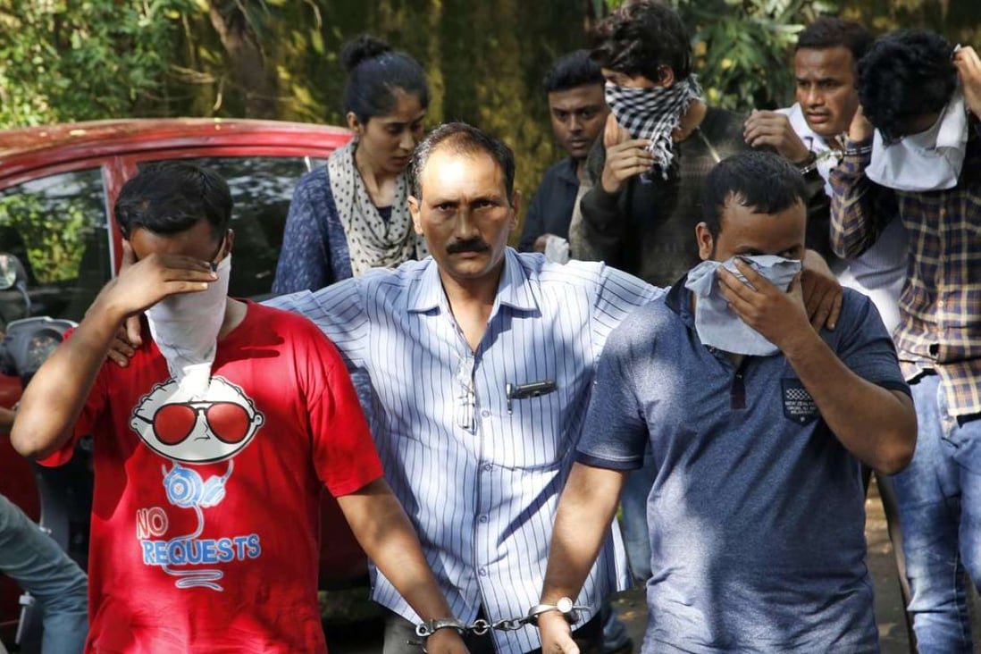 A police official (centre) escorts two men, arrested over a tax scam, outside the court in Thane, outskirts of Mumbai, India. Photo: AP