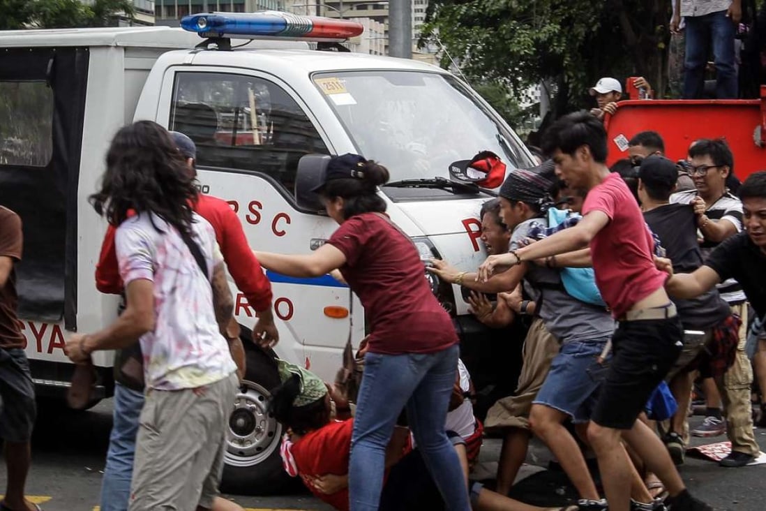 A police van runs over protesters during a protest in front of the US Embassy in Manila. Photo: EPA