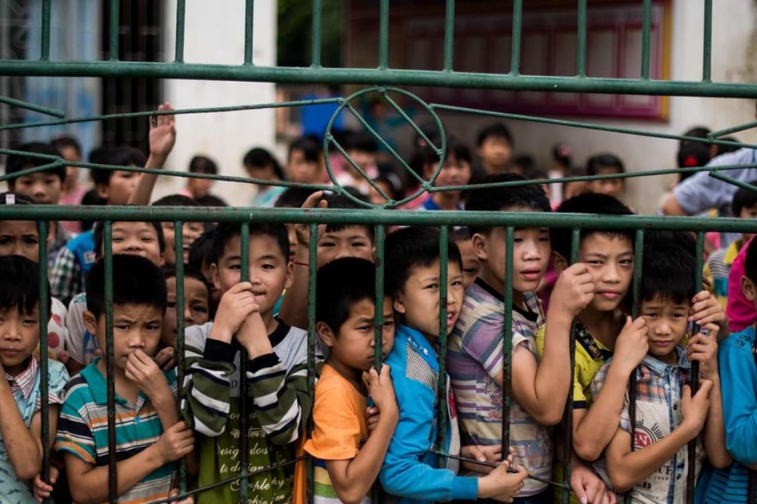 Pupils gather at the school gates of Xianghe, Guangxi province. Such rural areas have large populations of left-behind children. Photo: AFP