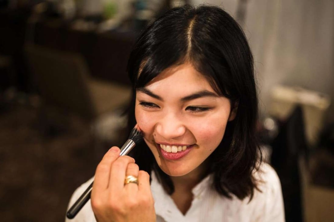 A stylist works on the make-up for Japanese model Rina Fukushi. Photo: AFP