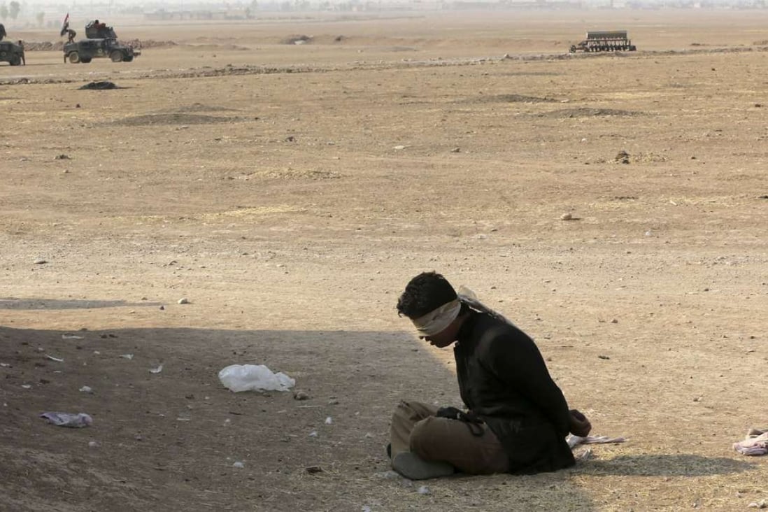 A suspected fighter for the Islamic State group sits handcuffed in the village of Tob Zawa, about 9km from Mosul, on Tuesday after his capture by Iraqi commandoes. Photo: AP