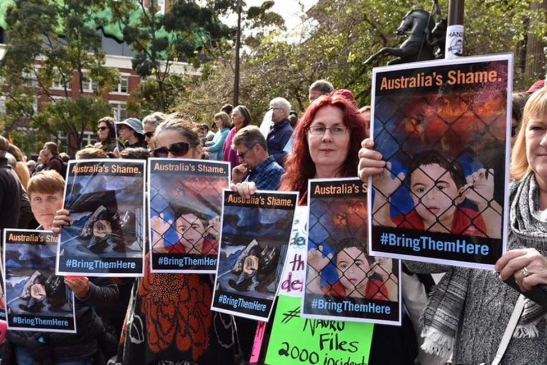 Australian demonstrators hold artworks by Abbas Alaboudi at a protest against offshore processing centres in August. Photo: Rod Hysted