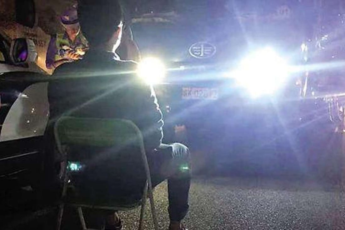 A motorist is made to stare into car headlights. Photo: Sina.com.cn