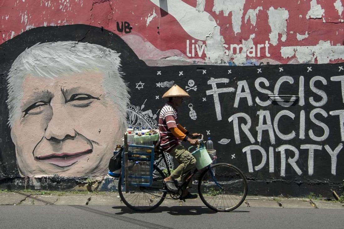 A man cycles past graffiti depicting US Republican presidential nominee Donald Trump, on a street in Surabaya, Indonesia's east Java. Photo: AFP
