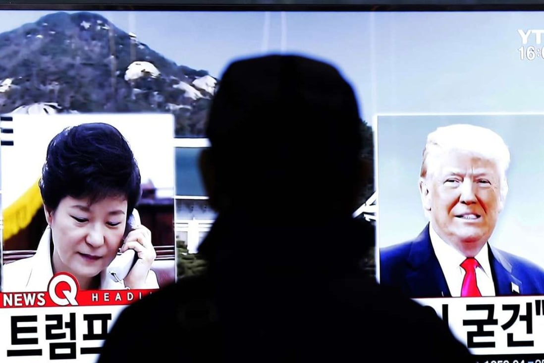 A man watches a TV screen showing pictures of US President-elect Donald Trump, right, and South Korean President Park Geun-hye at the Seoul Railway Station in Seou on Thursday. Photo: AP