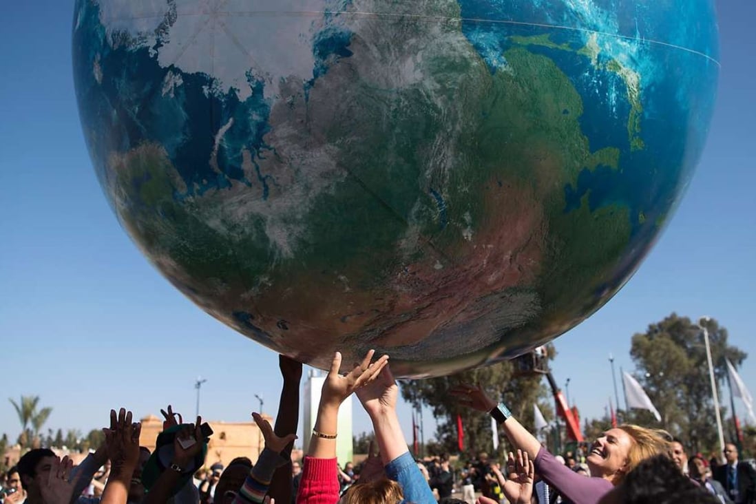 Members of International delegations play with a giant air globe ball outside the COP22 climate conference. Photo: AFP