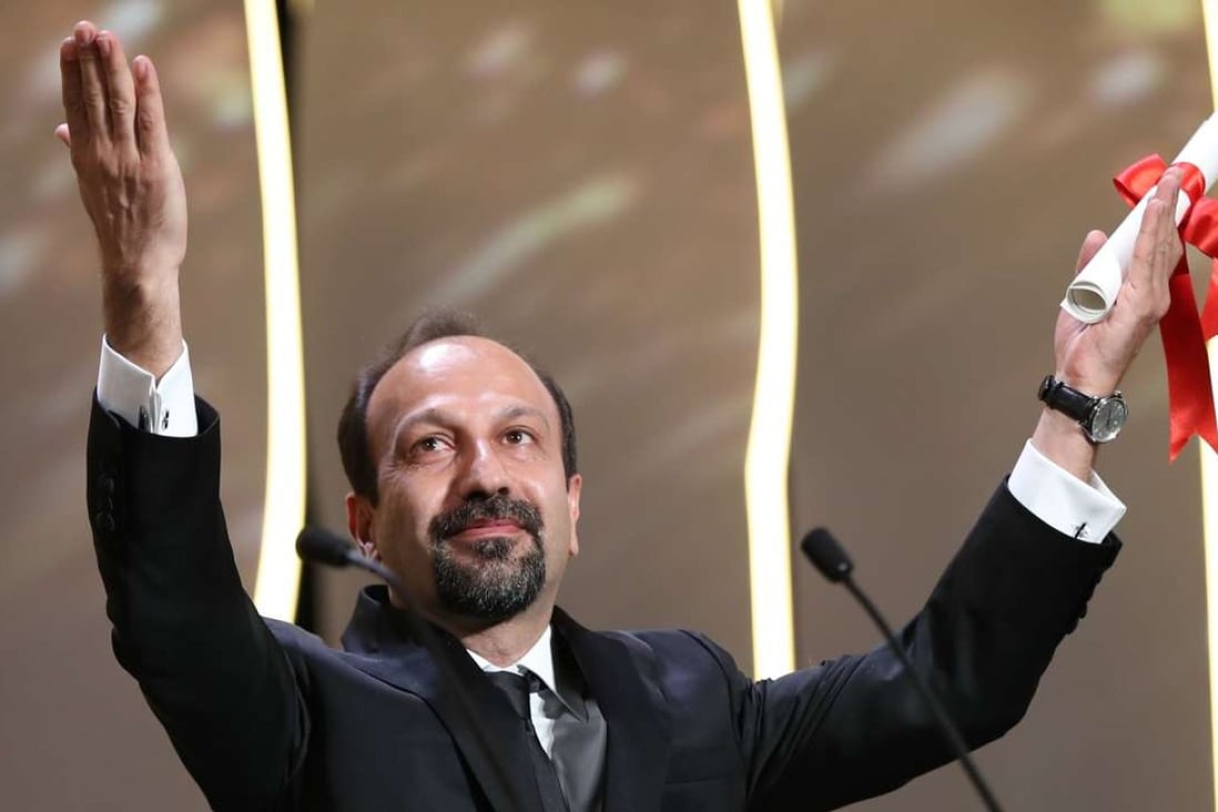 Iranian director Asghar Farhadi celebrates on stage after winning the best screenplay prize for The Salesman at the 2016 Cannes Film Festival. Photo: AFP