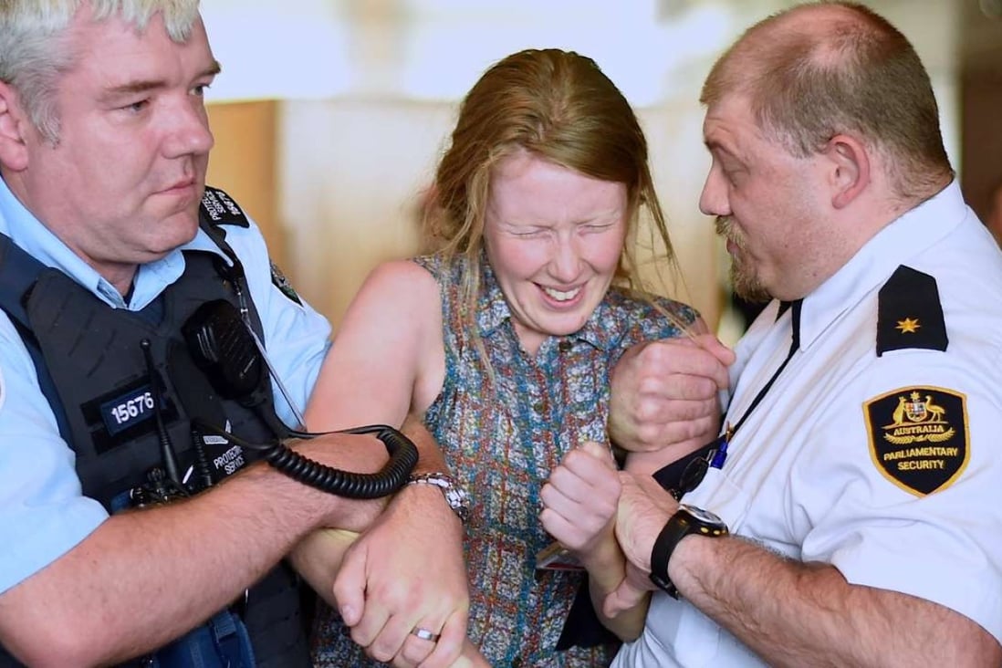 Australian activists superglue themselves to railings during protest in
